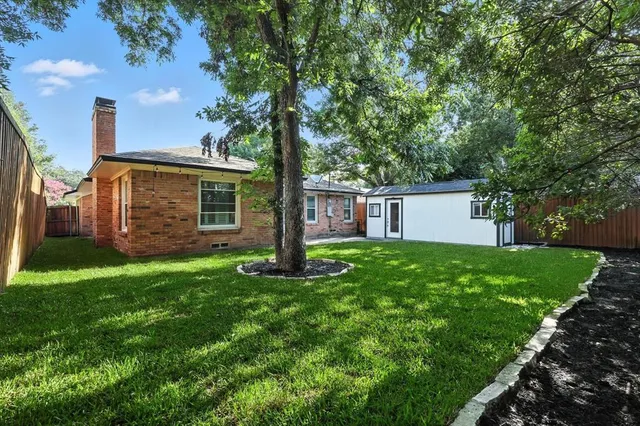 a view of a house with backyard and a tree