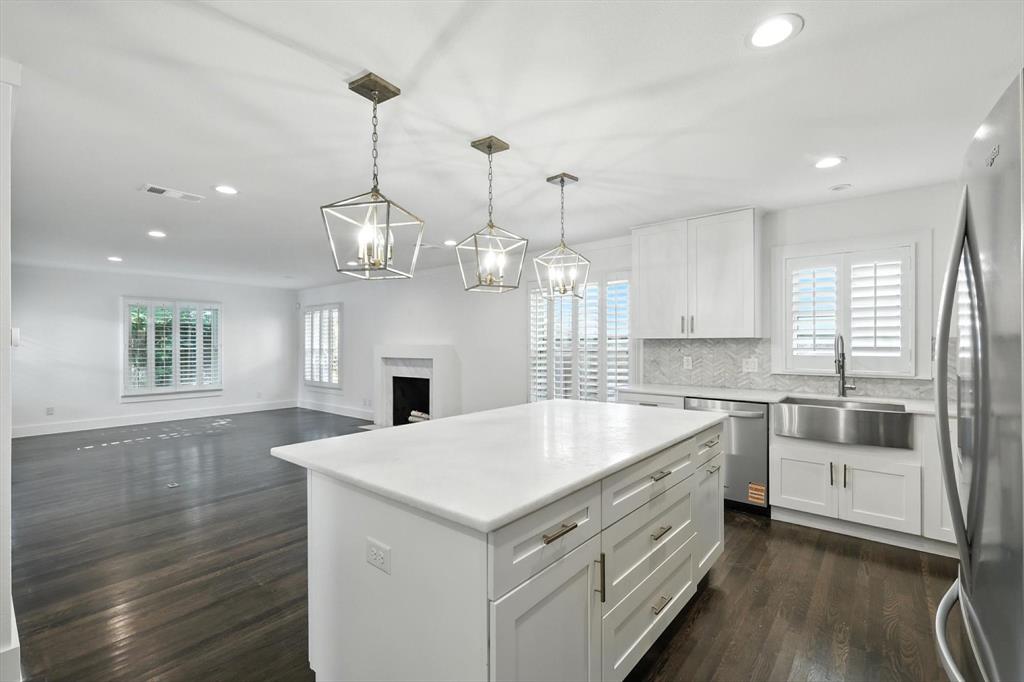 6116 St Moritz Avenue Dallas, TX 75214 - Photo 8 of 40 a large kitchen with kitchen island a stove a sink a center island and wooden floor