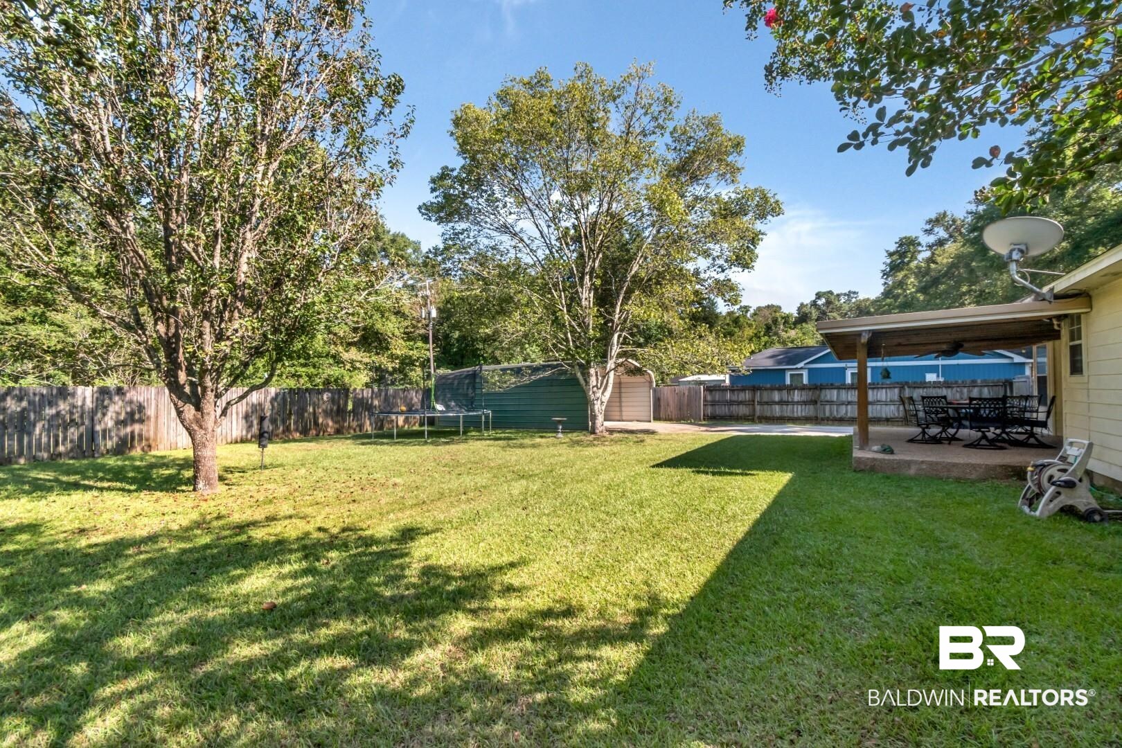 1345 Camden Court Mobile, AL 36695 - Photo 23 of 31 Fenced backyard with a trampoline, a patio, and a storage unit
