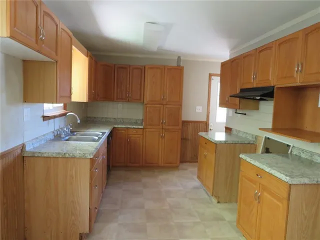 a kitchen with granite countertop a sink a stove and a refrigerator