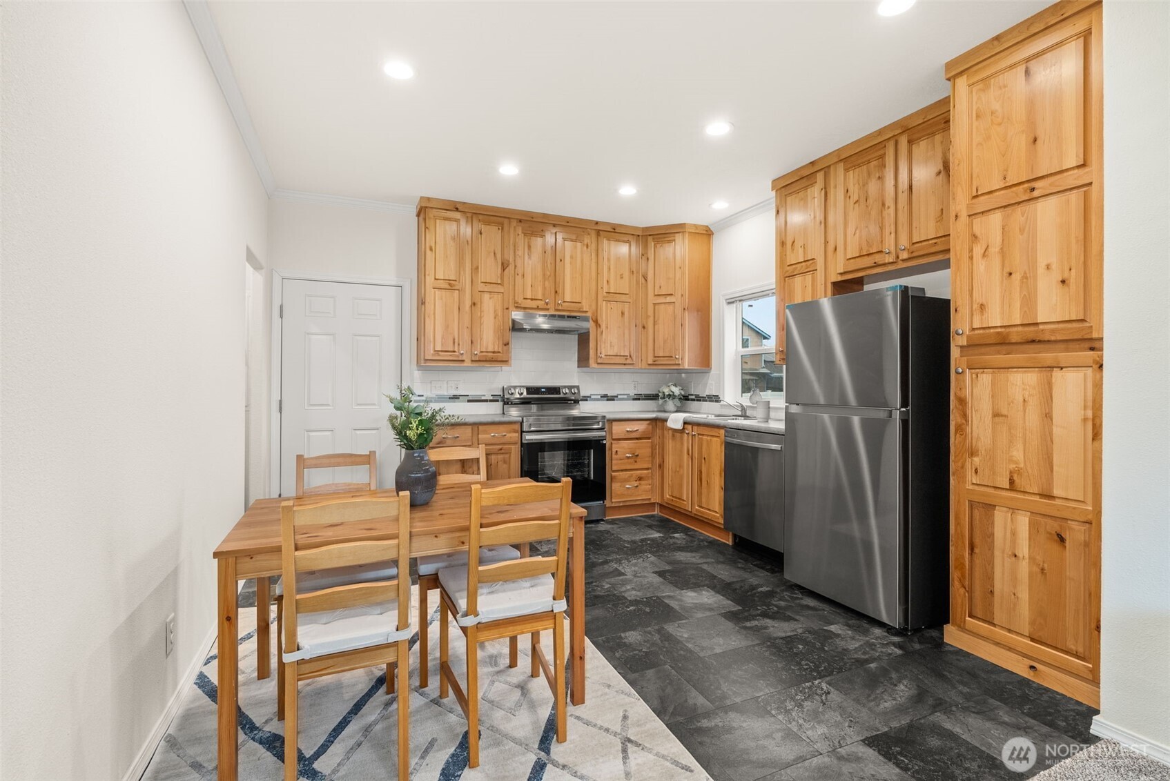 1257 Southwest Elzina Street Chehalis, WA 98532 - Photo 7 of 28 a kitchen with granite countertop a refrigerator stove top oven dining table and chairs