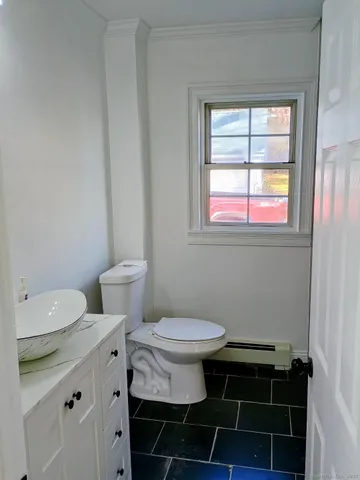 a bathroom with a toilet a sink and a window