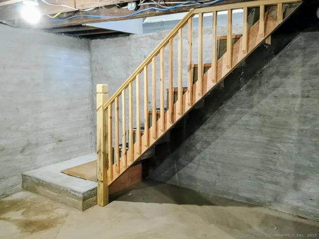 a view of staircase with lots of frames on wall and wooden floor