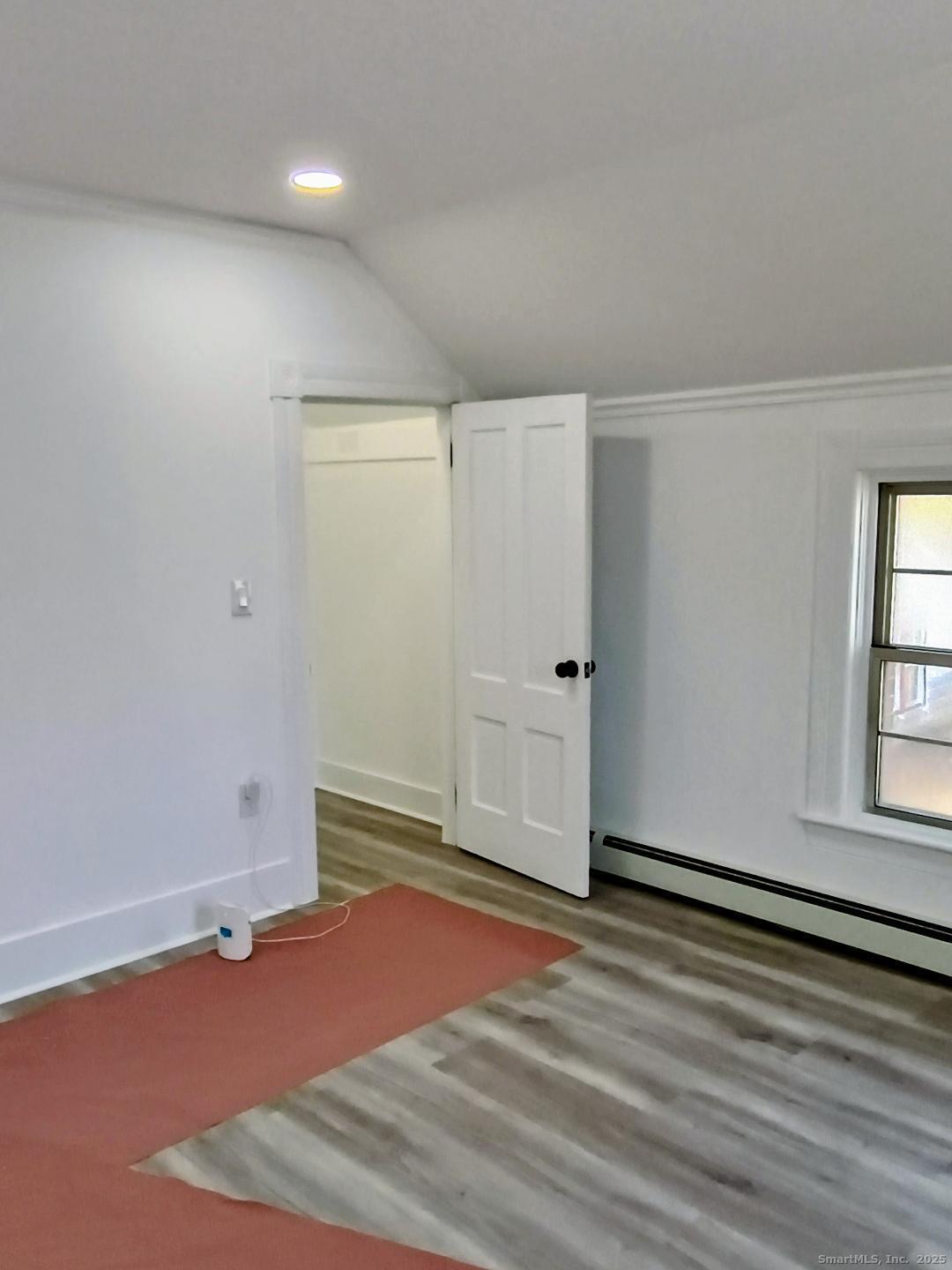 633 Wauregan Road Brooklyn, CT 06234 - Photo 5 of 15 an empty room with wooden floor and windows