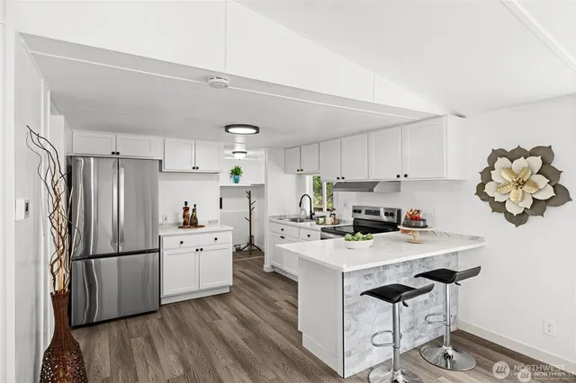 a kitchen with stainless steel appliances a stove a sink cabinets and a refrigerator