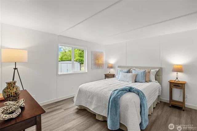 a bedroom with a bed and wooden floor