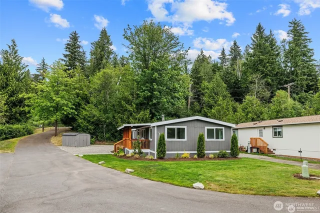 a front view of a house with a yard and trees