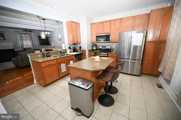 a kitchen with a sink a kitchen island a stove and a refrigerator with wooden floor