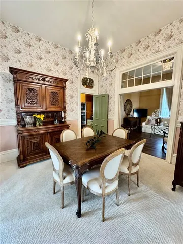 a dining room with furniture a rug and a chandelier