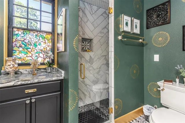 a bathroom with a granite countertop sink a toilet and shower