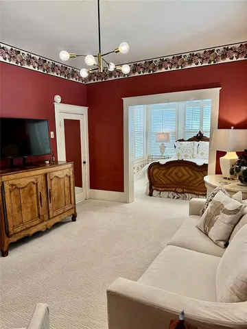 a living room with furniture a chandelier and a flat screen tv