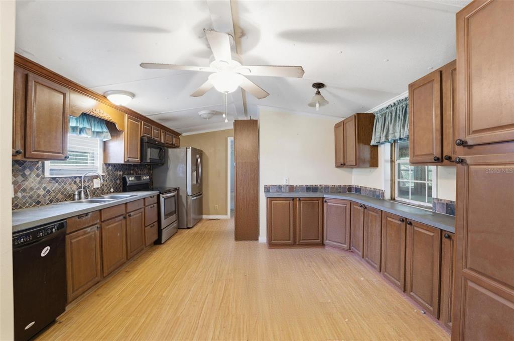2220 Ellie Road, Unit A Auburndale, FL 33823 - Photo 13 of 41 a large kitchen with stainless steel appliances kitchen island granite countertop a sink and cabinets