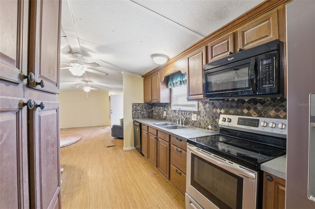 2220 Ellie Road, Unit A Auburndale, FL 33823 - Photo 14 of 41 a kitchen with stainless steel appliances a stove sink and cabinets