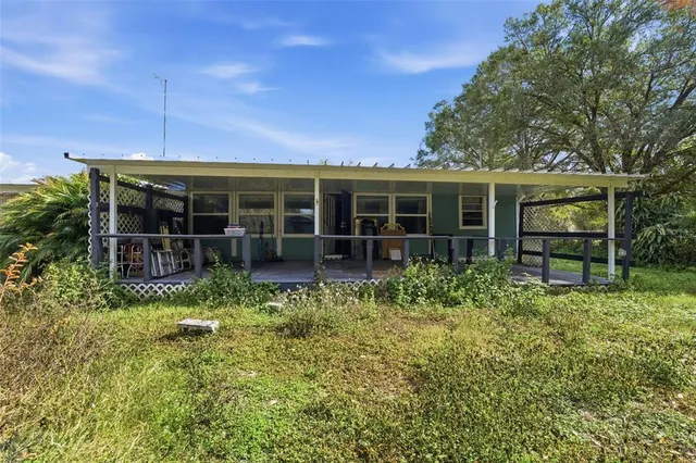 a view of a house with backyard and sitting area