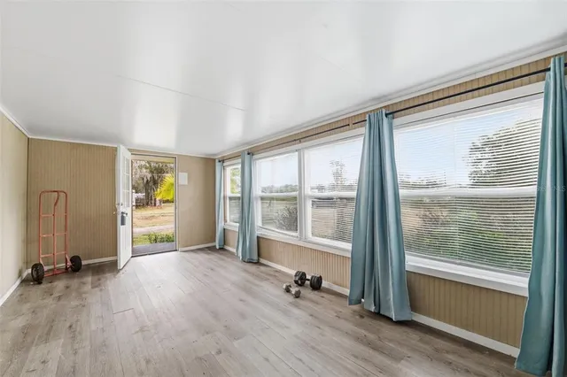 a view of a big room with wooden floor and windows