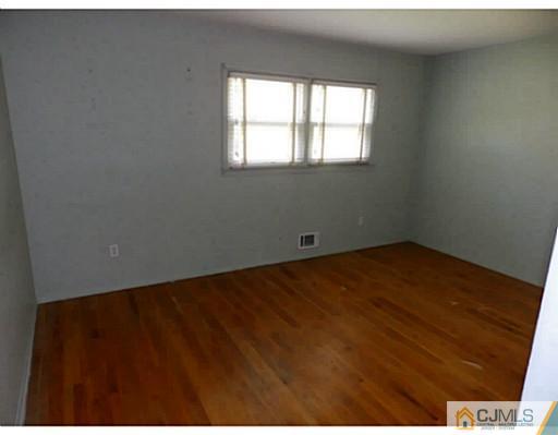 22 Lynnwood Road Edison, NJ 08820 - Photo 12 of 19 an empty room with wooden floor and windows