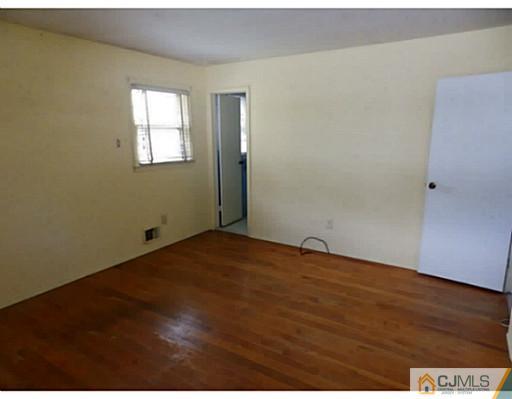 22 Lynnwood Road Edison, NJ 08820 - Photo 14 of 19 an empty room with wooden floor and windows