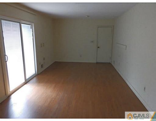 22 Lynnwood Road Edison, NJ 08820 - Photo 8 of 19 an empty room with wooden floor and windows