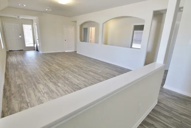 a view of an empty room and wooden floor