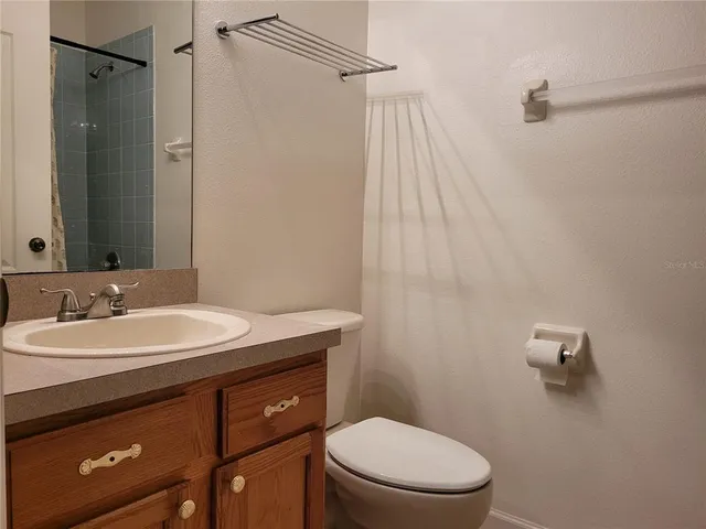 a bathroom with a sink a toilet a mirror and shower