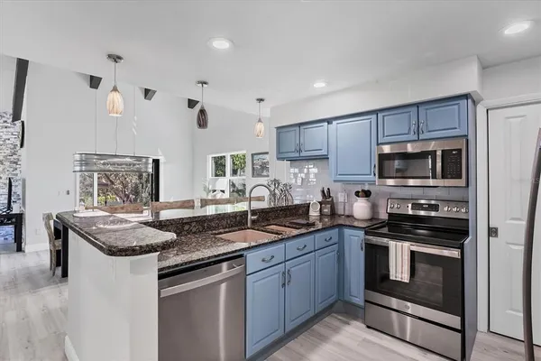 a kitchen with granite countertop stainless steel appliances and white cabinets