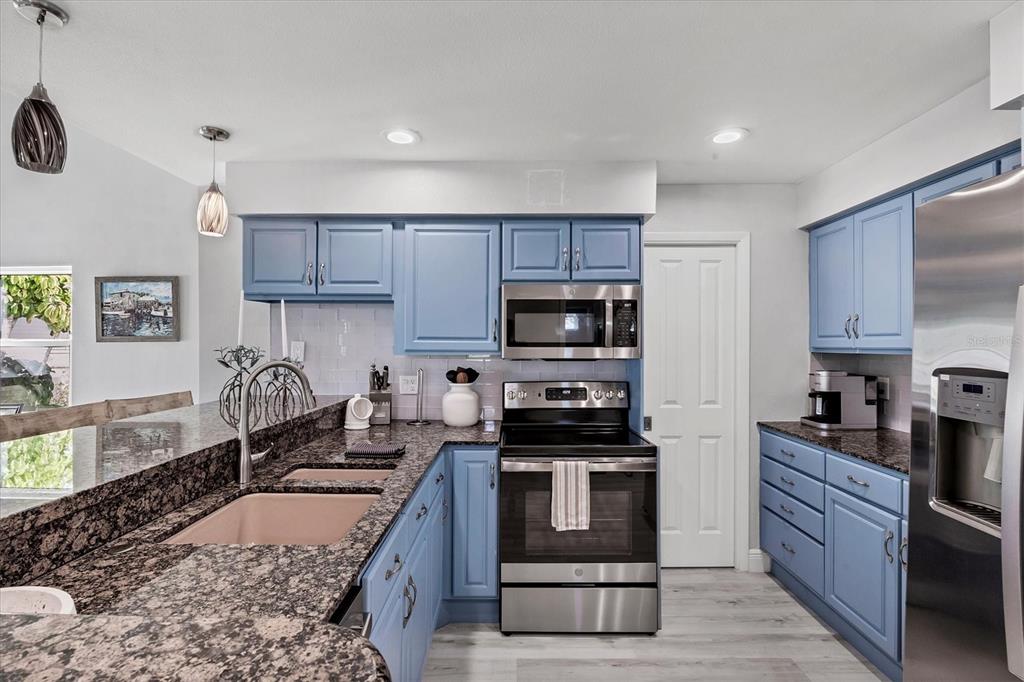 401 Lafitte Street Boca Grande, FL 33921 - Photo 12 of 37 a kitchen with stainless steel appliances granite countertop a stove a sink and a refrigerator