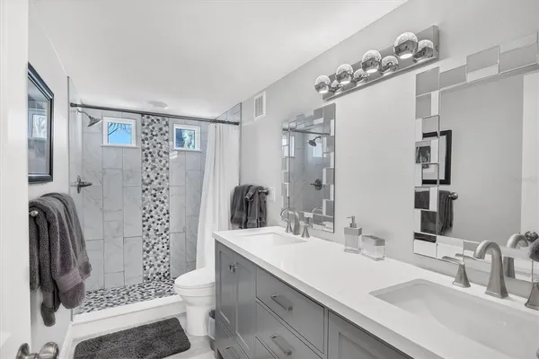 a bathroom with a sink double vanity and a mirror