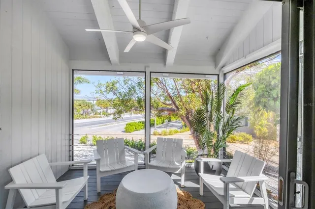 a living room with large windows and a table