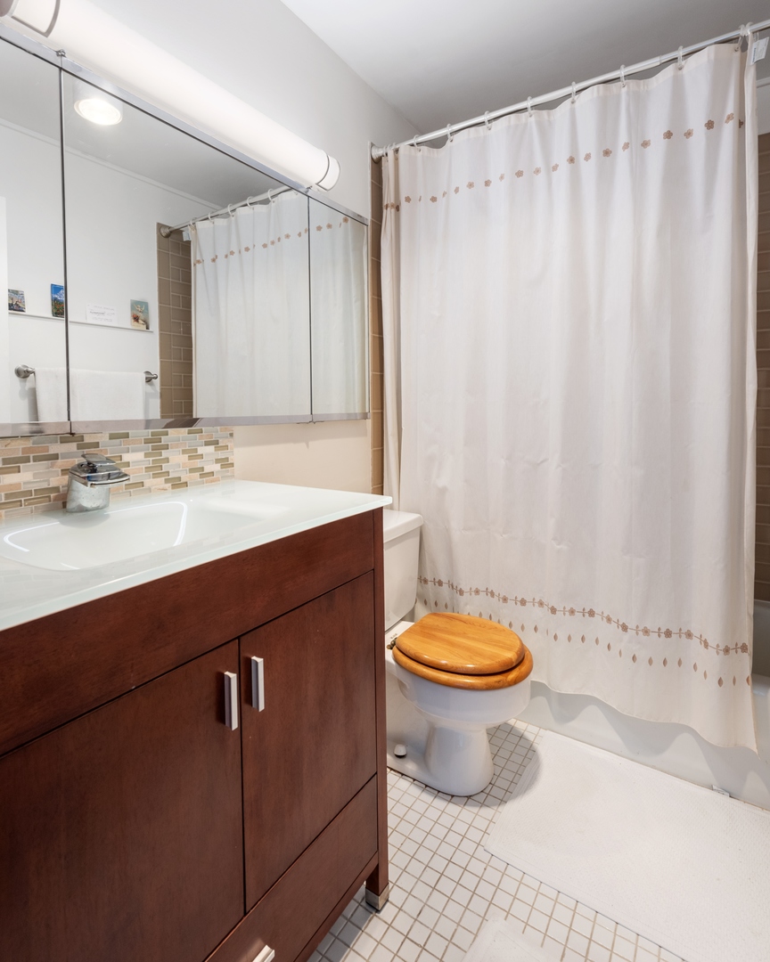 5445 North Sheridan Road, Unit 1212 Chicago, IL 60640 - Photo 9 of 14 a bathroom with a sink a toilet and a mirror