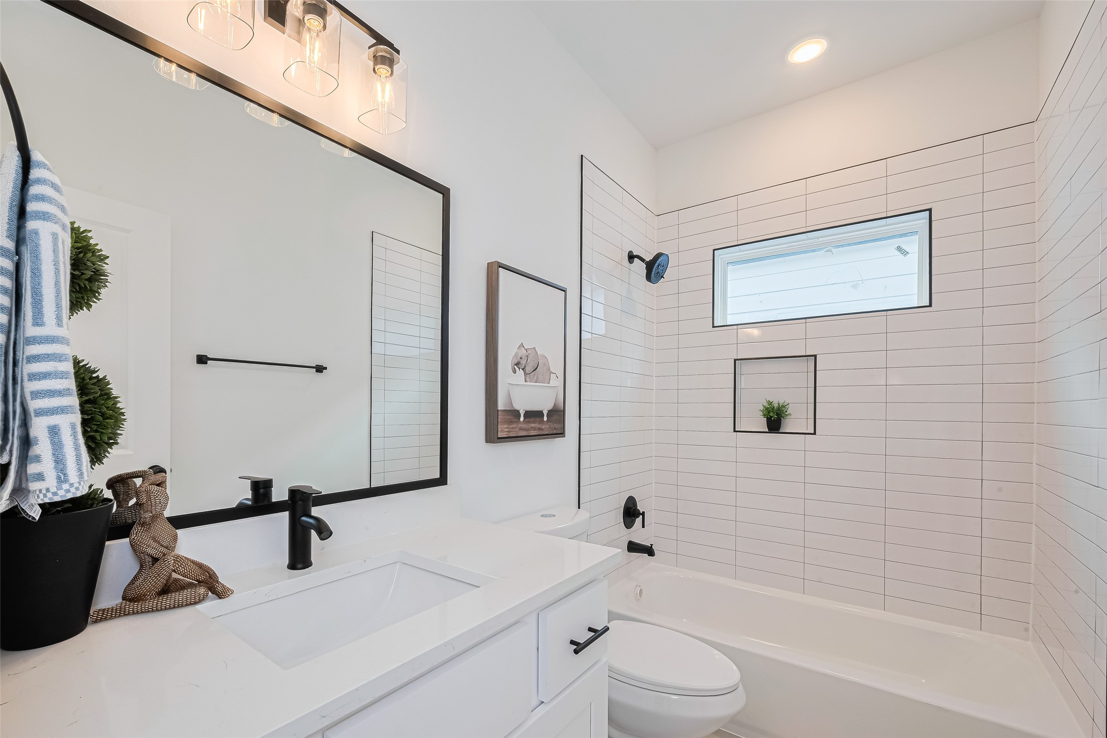 9437 Pembrook Street Houston, TX 77016 - Photo 20 of 25 a bathroom with a toilet a sink a mirror a bathtub and vanity