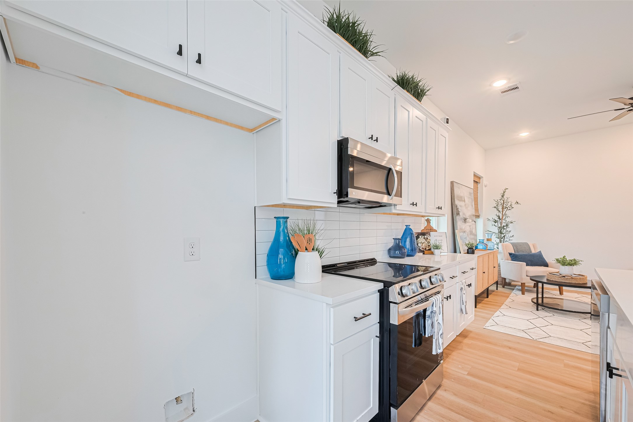 9437 Pembrook Street Houston, TX 77016 - Photo 6 of 25 a kitchen with stainless steel appliances a sink dishwasher stove refrigerator and microwave with wooden floor