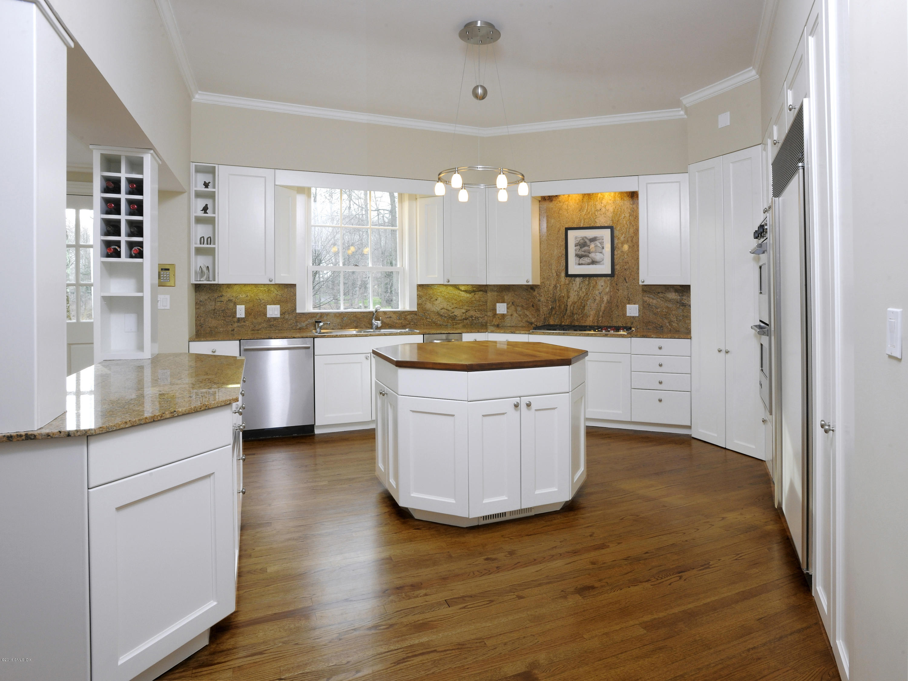 526 North Street Greenwich, CT 06830 - Photo 17 of 40 a large kitchen with kitchen island a sink a stove a refrigerator and white cabinets with wooden floor