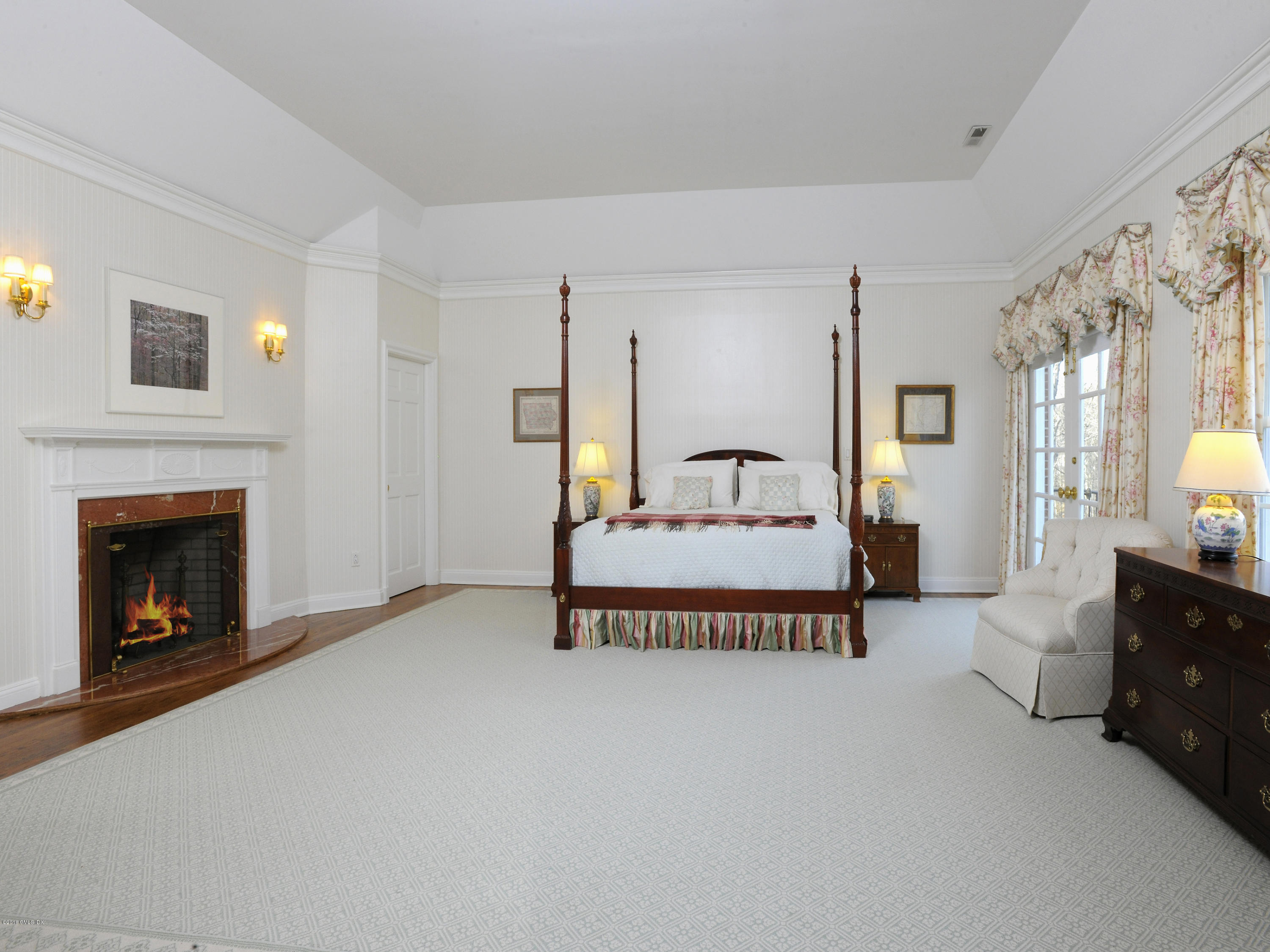 526 North Street Greenwich, CT 06830 - Photo 21 of 40 a spacious bedroom with a bed and a fireplace