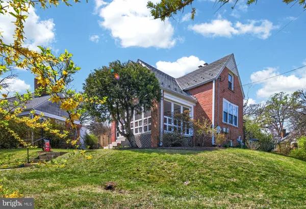 a view of a house with a big yard and large trees