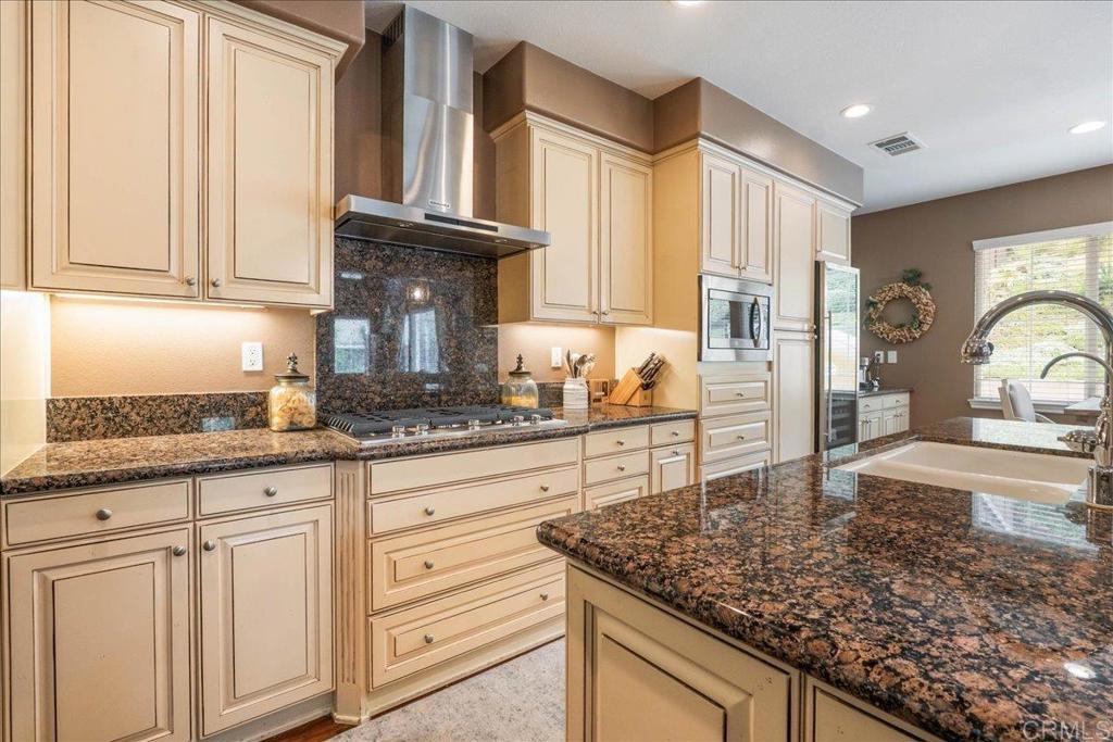 6996 Goldstone Road Carlsbad, CA 92009 - Photo 13 of 49 a kitchen with granite countertop a sink a stove and cabinets