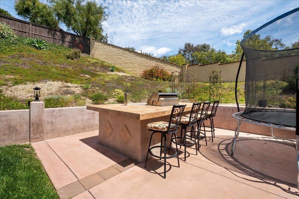 6996 Goldstone Road Carlsbad, CA 92009 - Photo 20 of 49 a view of a patio with a table and chairs