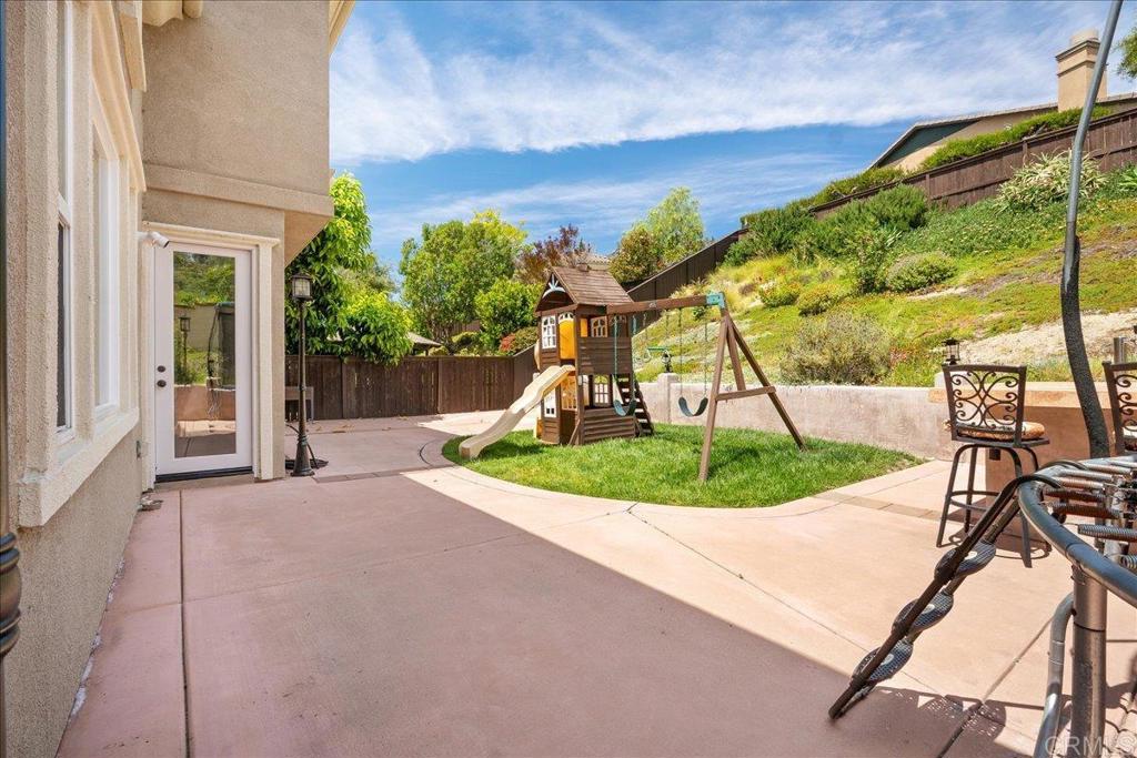 6996 Goldstone Road Carlsbad, CA 92009 - Photo 23 of 49 a view of a swimming pool with a porch and couches next to red door