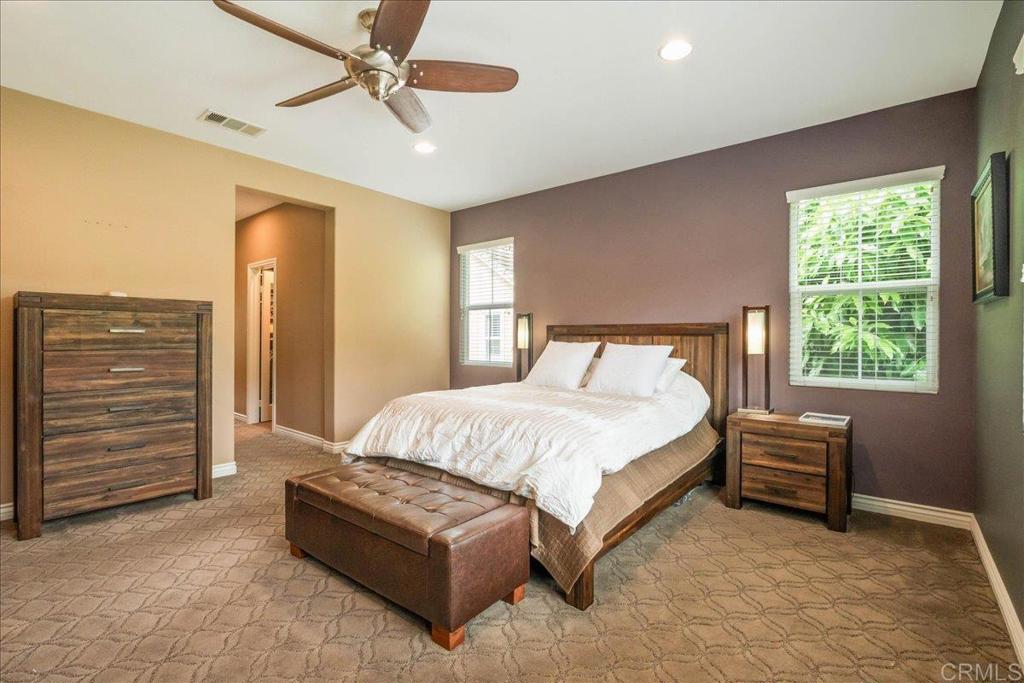 6996 Goldstone Road Carlsbad, CA 92009 - Photo 28 of 49 a bedroom with a bed a dresser and a chandelier