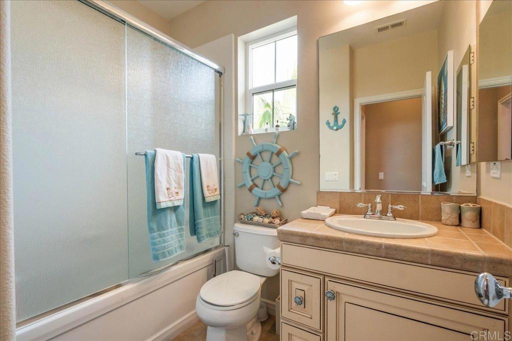 6996 Goldstone Road Carlsbad, CA 92009 - Photo 41 of 49 a bathroom with a granite countertop sink a toilet and shower