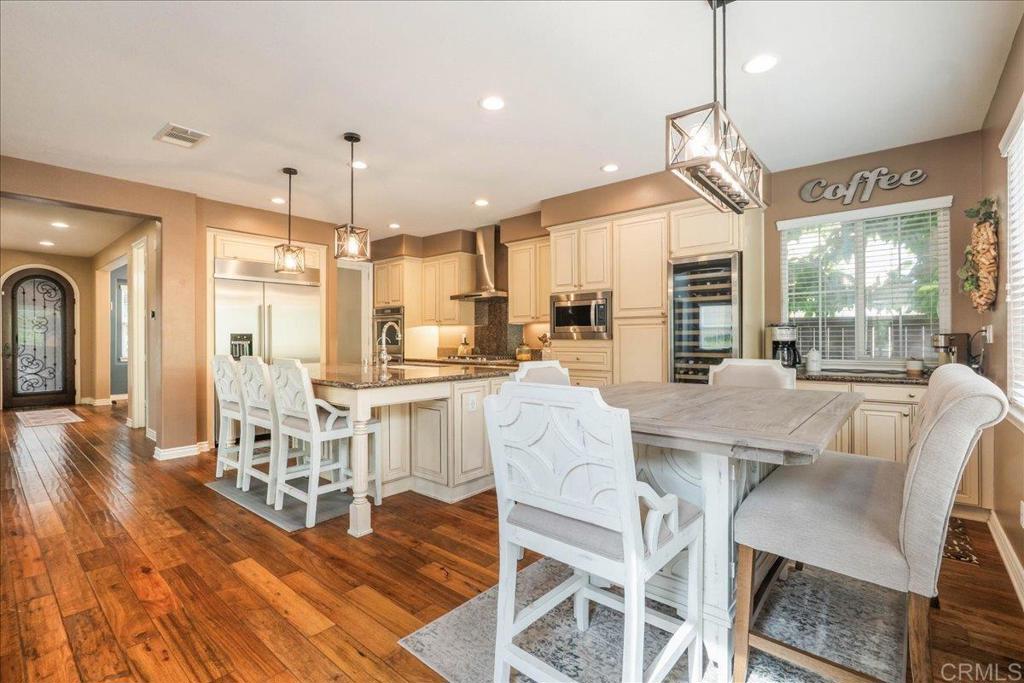6996 Goldstone Road Carlsbad, CA 92009 - Photo 9 of 49 a dining room with furniture a chandelier and wooden floor