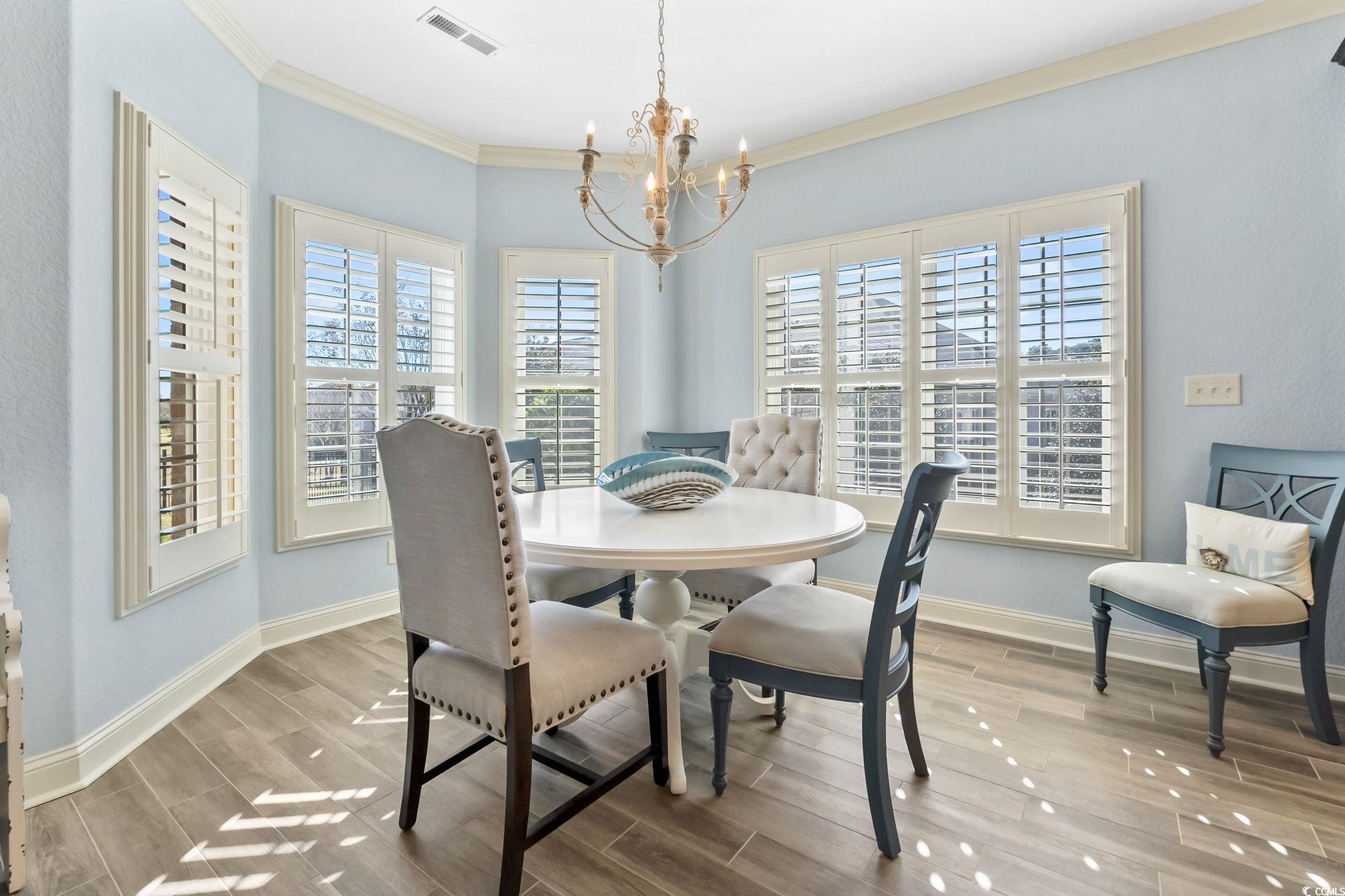 750 Villarosa Drive Myrtle Beach, SC 29572 - Photo 12 of 40 Dining space featuring wood finish floors, a chandelier, and ornamental molding