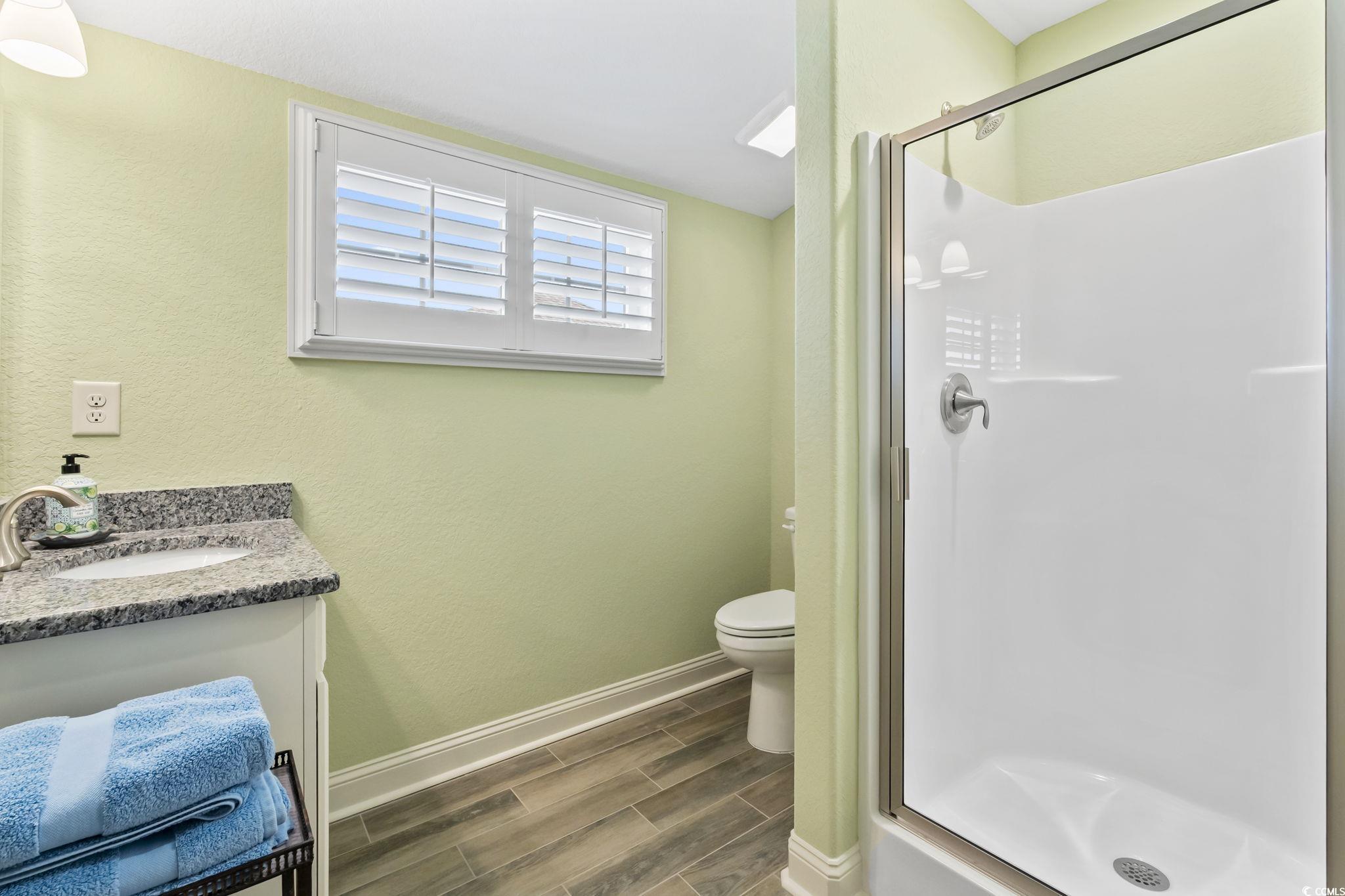 750 Villarosa Drive Myrtle Beach, SC 29572 - Photo 27 of 40 Full bath with vanity, wood tiled floors, a shower stall, and a textured wall
