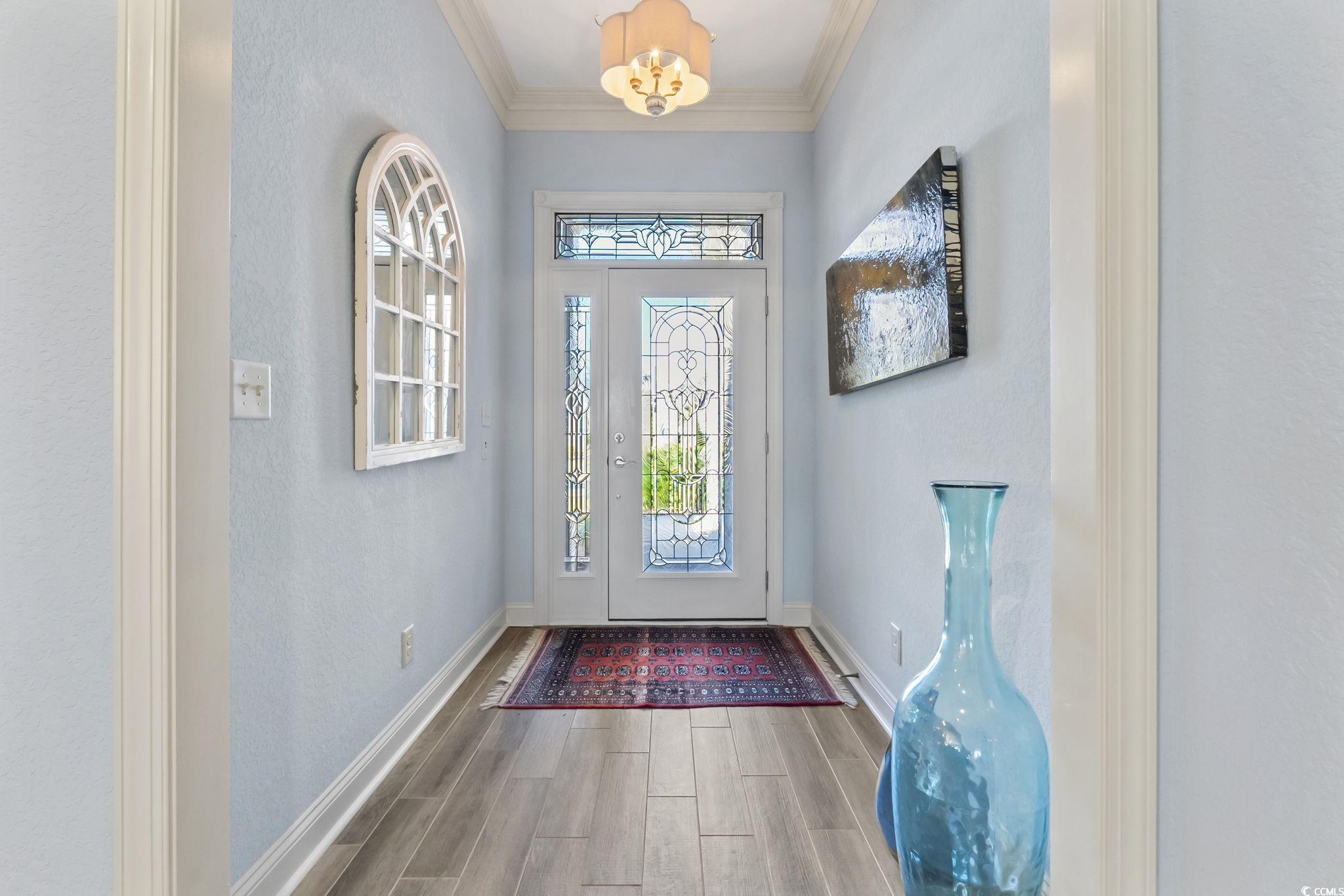 750 Villarosa Drive Myrtle Beach, SC 29572 - Photo 3 of 40 Entryway featuring wood finish floors, a chandelier, and crown molding