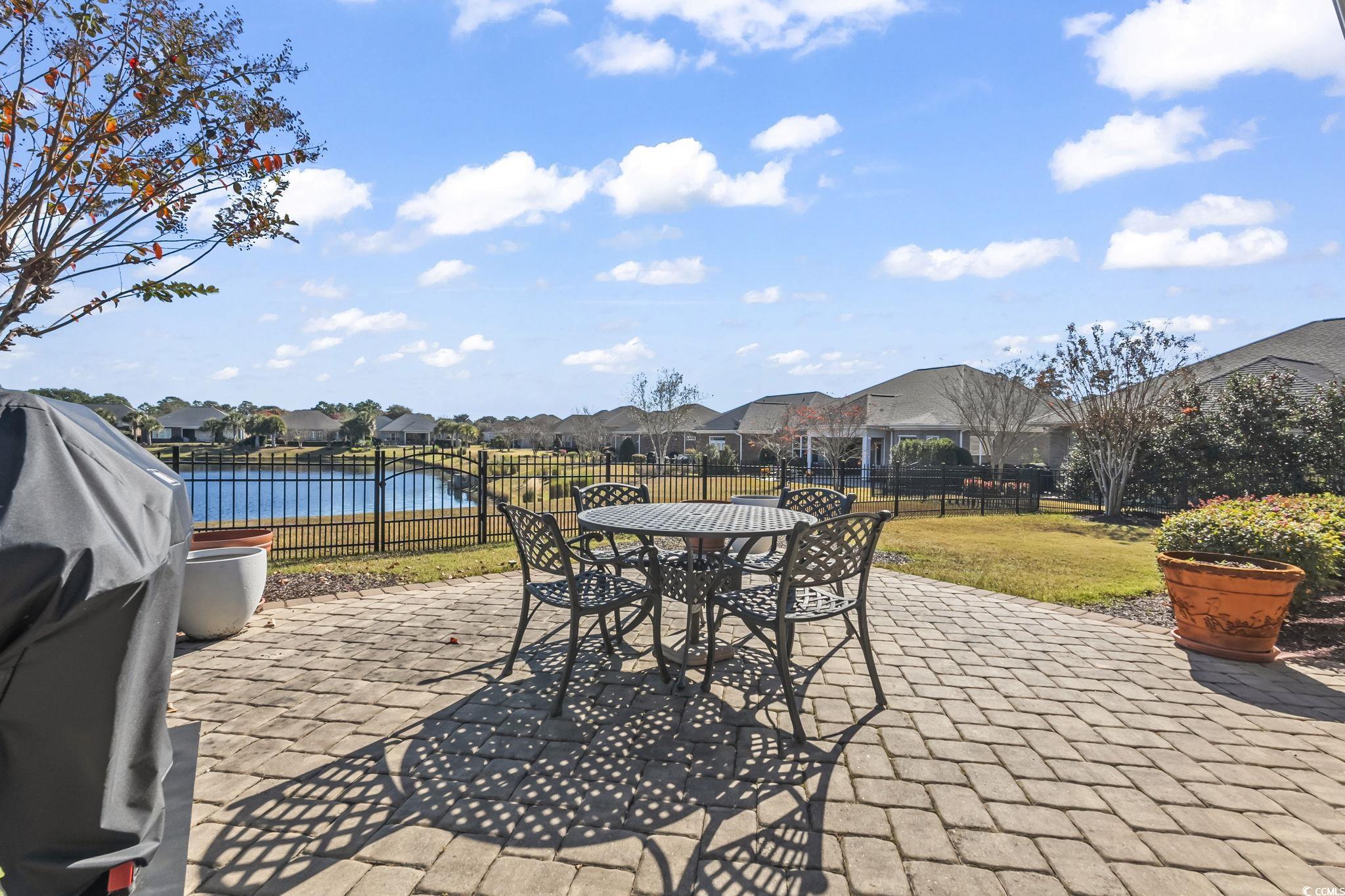750 Villarosa Drive Myrtle Beach, SC 29572 - Photo 31 of 40 Fenced backyard featuring a residential view, outdoor dining area, a patio, a grill, and a water view