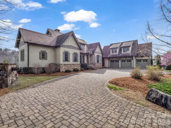 a view of a big house with a big yard and large trees