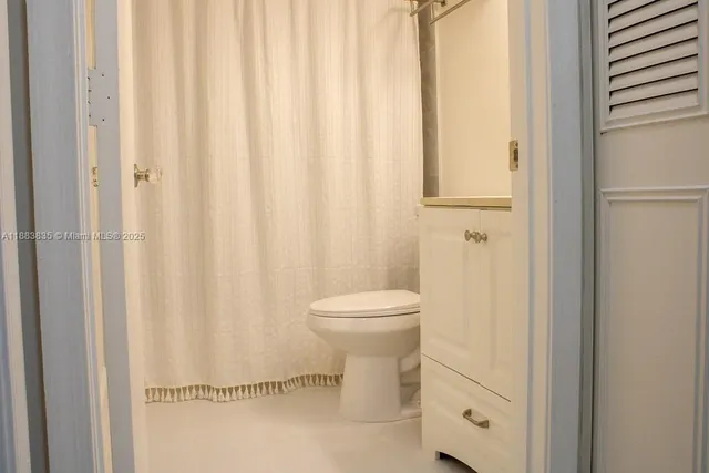 a bathroom with a toilet and shower curtain