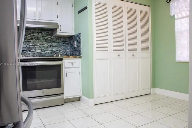 a view of kitchen with granite countertop cabinets appliances and a window