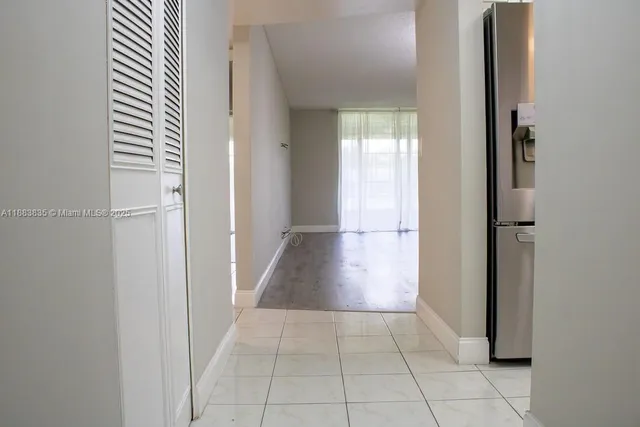 a view of a hallway with wooden floor and a room