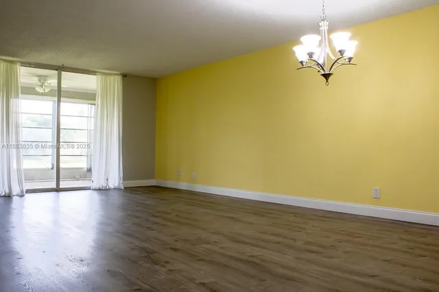 a view of a room with wooden floor and large windows