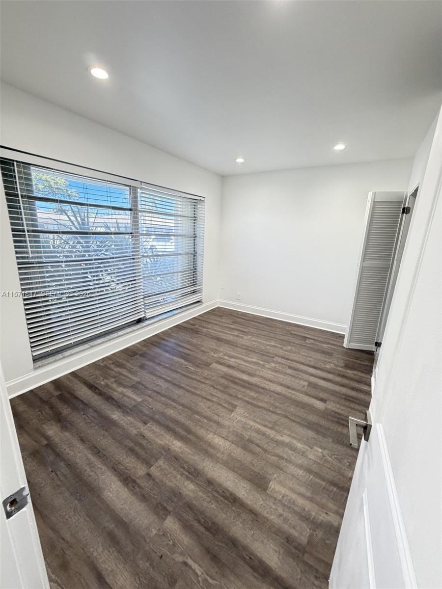 20927 Sedgewick Drive Boca Raton, FL 33433 - Photo 22 of 24 en empty room with wooden floor and windows